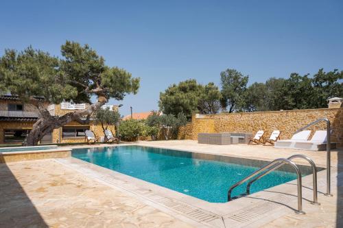 a swimming pool in a yard with chairs and trees at Aeolia Villa Athenian Riviera in Anavissos