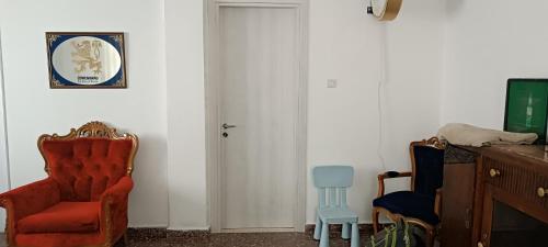 una stanza con una sedia rossa e una porta bianca di Chris's house in Spetses a Spetses