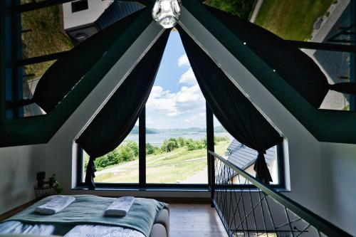 a bedroom with a bed and a large window at Panorama Hills by Housine in Jaszczurowa