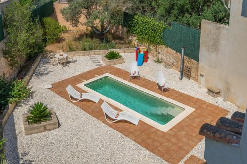 a swimming pool with two chairs and a swimming poolvisorangering at RostoIl Espai de Calma in Muro