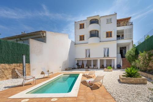 a villa with a swimming pool in front of a house at RostoIl Espai de Calma in Muro