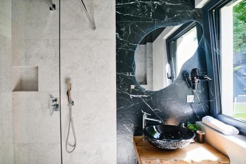 a bathroom with a black sink and a mirror at Panorama Hills by Housine in Jaszczurowa