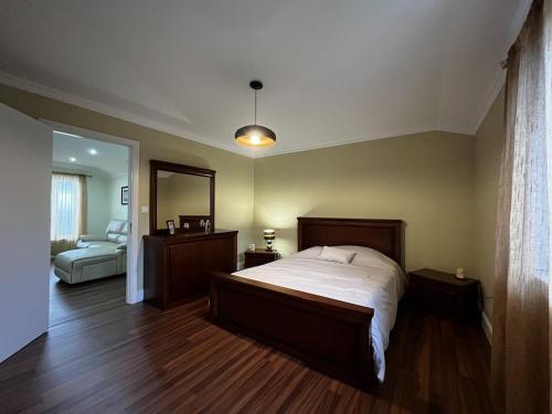 a bedroom with a large bed and a mirror at Casa da Ribeira - Azores in Ponta Garça