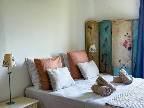 a bed with colorful pillows on top of it at Maison de village avec vue panoramique proche Gordes in Joucas