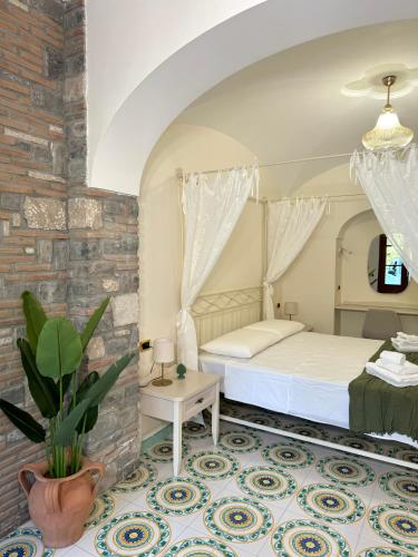 a bedroom with a bed and a brick wall at Casa della Riviera Sorrento in Sorrento