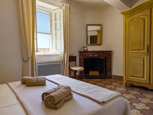 a bedroom with a bed with towels on it at Maison de village avec vue panoramique proche Gordes in Joucas