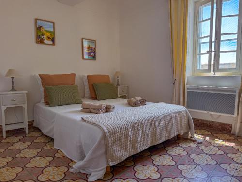 a bedroom with a bed and a window at Maison de village avec vue panoramique proche Gordes in Joucas