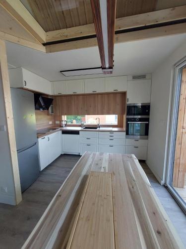 a kitchen with white cabinets and a wooden table at Le Dreispitz, Gîte d'Exception en Alsace in Gresswiller