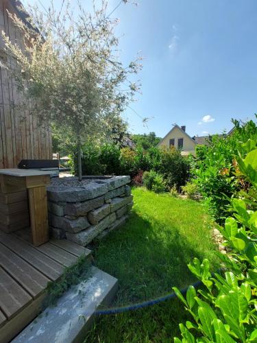 a garden with a stone retaining wall and a bench at Le Dreispitz, Gîte d'Exception en Alsace in Gresswiller