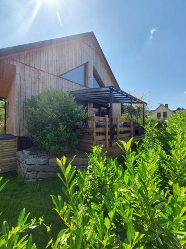 a house with a wooden deck with a black umbrella at Le Dreispitz, Gîte d'Exception en Alsace in Gresswiller