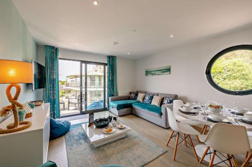a living room with a couch and a table at 9 Middlecombe - Luxury Apartment at Byron Woolacombe, only 4 minute walk to Woolacombe Beach! in Woolacombe