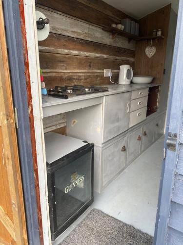 a kitchen with a stove and a counter top at Hopgarden Glamping and camping - Luxury furnished Bell tents & Shepherd huts plus camp field to pitch your own tents in Wadhurst