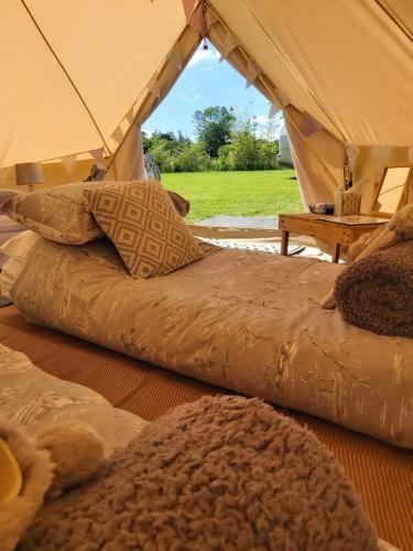 two beds sitting inside of a tent at Hopgarden Glamping and camping - Luxury furnished Bell tents & Shepherd huts plus camp field to pitch your own tents in Wadhurst