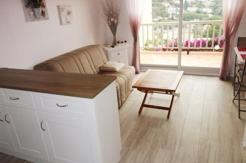 un salon avec un canapé et une table dans l'établissement Studio Mezzanine 4 personnes PISCINE VUE MER, à Cavalaire-sur-Mer