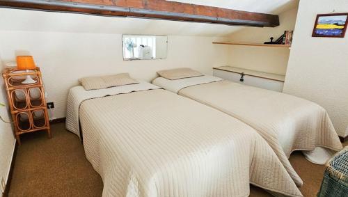 une chambre avec deux lits dans une pièce dans l'établissement Studio Mezzanine 4 personnes PISCINE VUE MER, à Cavalaire-sur-Mer