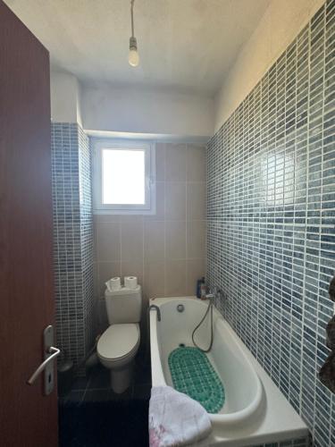 a bathroom with a toilet and a bath tub at Yucca house in Elani