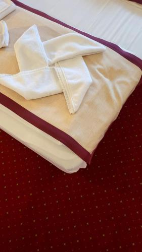 a white robe sitting on top of a bed at Hotel Carpați in Predeal