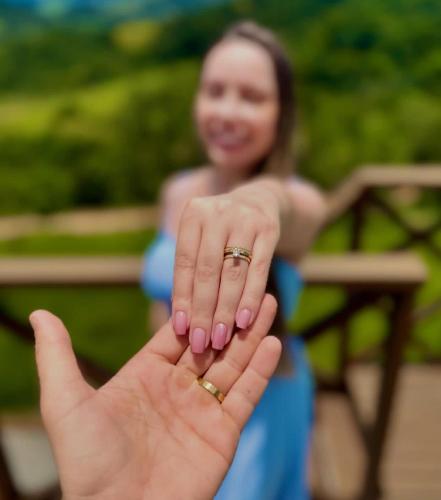 a woman holding up a hand with a ring on it at Chalé Mirante da Serra Sapucaí-Mirim in Sapucaí-Mirim