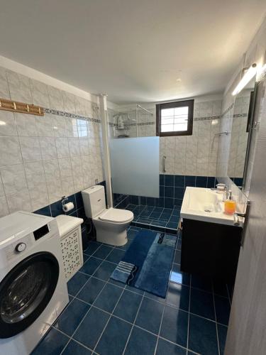a bathroom with a toilet and a sink and a washing machine at Natalie’s House in Alexandroupoli