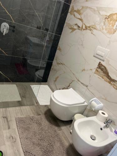 a bathroom with a white toilet and a sink at Halisof TEG residenziale 