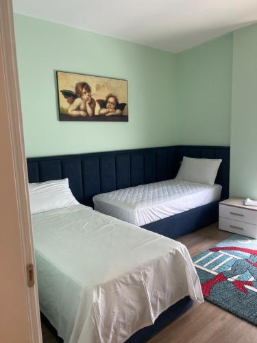 a bedroom with two beds and a painting on the wall at Halisof TEG residenziale 