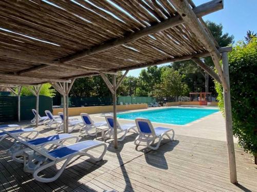 un groupe de chaises longues et une piscine dans l'établissement Camping 2 étoiles - Piscine - ccb0fdi, à Villeneuve-lès-Maguelone