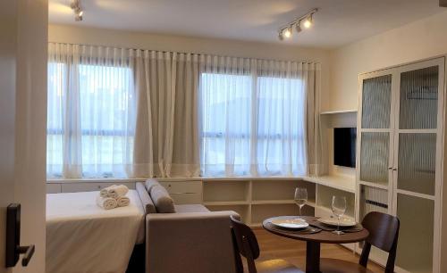 a hotel room with a bed and a table and a couch at Blend Coliving One - 2b in Ribeirão Preto