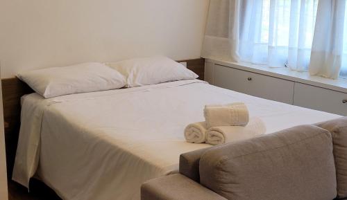 a bed with towels and a chair in a room at Blend Coliving One - 2b in Ribeirão Preto