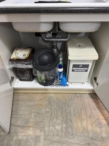 a drawer under a sink with various items underneath it at Trilocale vicino al mare in Lido di Ostia