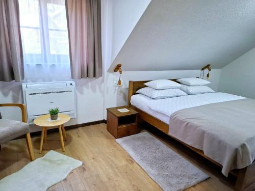 a bedroom with a large bed and a chair at B&B Plitvica Villa Prica in Plitvička Jezera