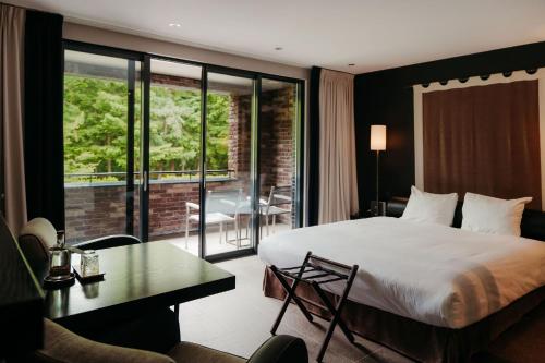 a hotel room with a large bed and a balcony at Hotel Gastronomique de Echoput in Apeldoorn