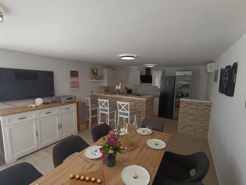 Un comedor con una mesa y una cocina. en Vila Ema Dramalj, en Dramalj