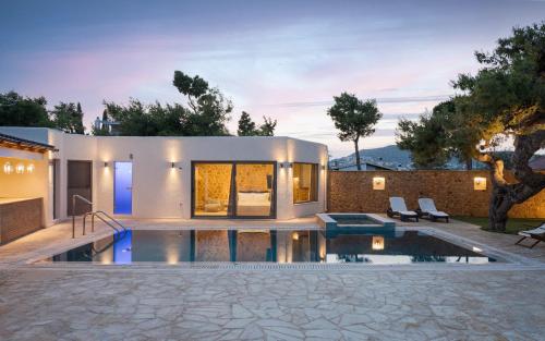 a house with a swimming pool in front of it at Aeolia Villa Athenian Riviera in Anavissos