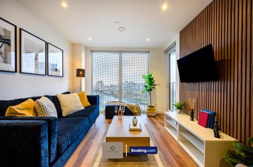 a living room with a blue couch and a tv at Hotel-Quality Flat By Paul & Malin Properties Short Term Rental Salford With Great City Access in Manchester