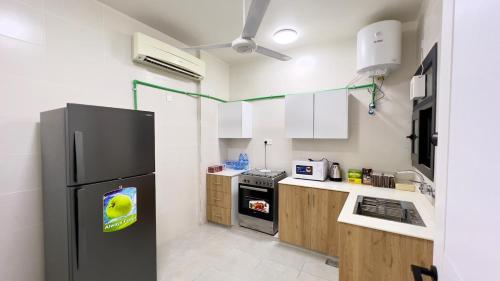 a kitchen with a black refrigerator and a stove at Alhamra Arc in Al Ḩamrāʼ