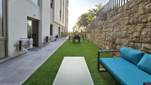 a garden with a bench and a stone wall at Tabarja Hills apartment in ‘Ayn aş Şughayrah