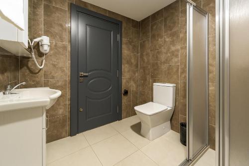 a bathroom with a toilet and a sink and a door at Monezza Avcılar in Istanbul