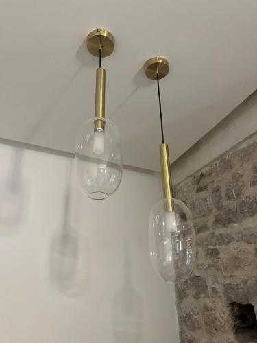 three glass lights hanging from a ceiling at Casa Del Sol Pietra Kotor in Kotor