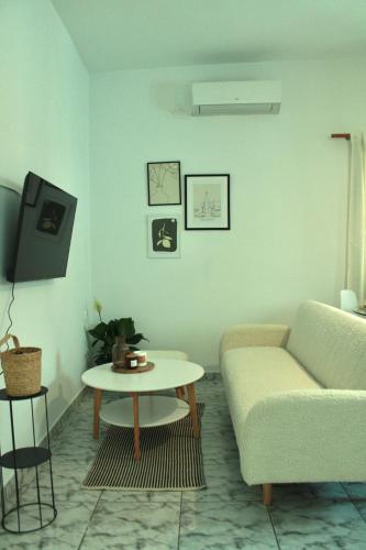 a living room with a couch and a table at Euphoria Suite - Endless View in Ermoupoli