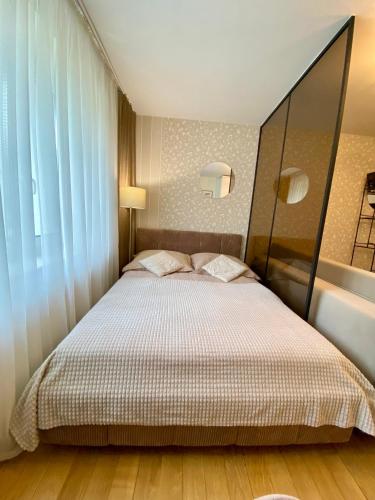 a bedroom with a large bed with a large window at Apartamenty na Klasztornej in Jasło