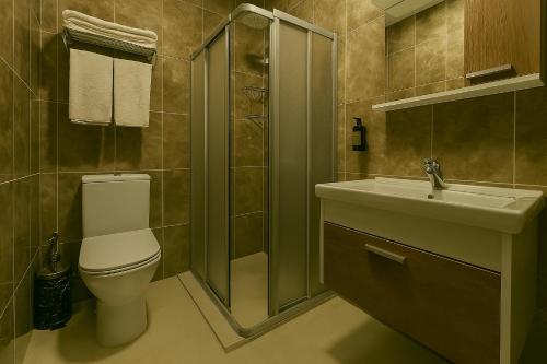 a bathroom with a toilet and a shower and a sink at Monezza Avcılar in Istanbul