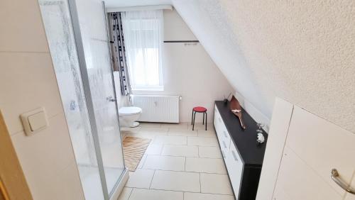 ein kleines weißes Bad mit einem WC und einem Fenster in der Unterkunft Ferienwohnung Seestern Ückeritz in Ückeritz