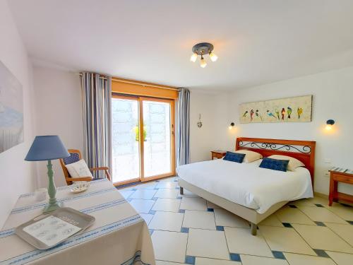 a bedroom with a bed and a table with a lamp at Maison Indépendante Sur Jardin in Mahalon