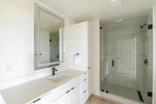 a white bathroom with a sink and a shower at Blueground Round Rock pool nr Old Settlers Park ATX-327 in Austin