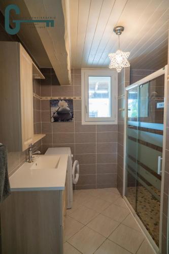 a bathroom with a sink and a shower at Séjour détente avec spa, piscine et sauna in Mas-Saintes-Puelles