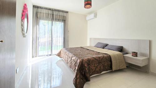 a bedroom with a bed and a large window at Tabarja Hills apartment in ‘Ayn aş Şughayrah