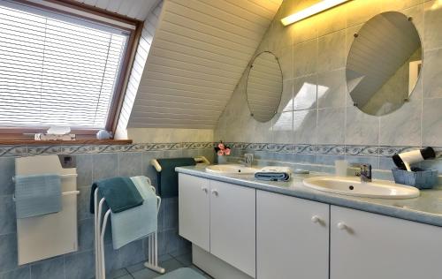 a bathroom with two sinks and two mirrors at Maison Indépendante Au Calme in Mahalon