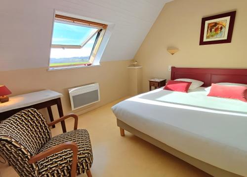 a bedroom with a bed and a chair and a window at Maison Indépendante Au Calme in Mahalon