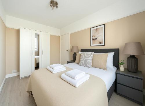 a bedroom with a bed with two white towels on it at Spacious 2-Bedroom Apartment in Crystal Palace in London
