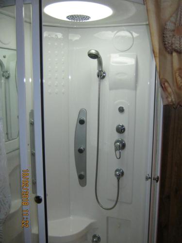 a shower door with a shower head and a shower at Pokój w centrum in Ustroń